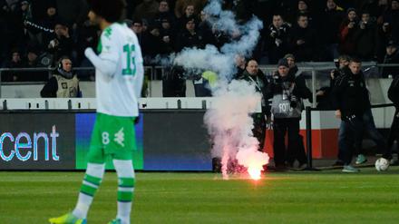 Wolfsburer Fans werfen Feuerwerk auf das Spielfeld.