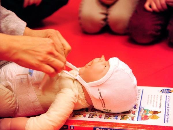 Kinderkrankenschwester Alexandra Götz macht die großen Schwestern und Brüder zu Mützenbeauftragten.