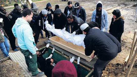 In Richtung Mekka. Ins Leichentuch gewickelt wird der Körper von Yusuf Aribidesi F. in das Grab hinuntergereicht.