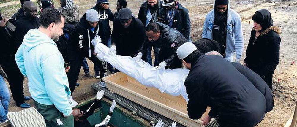In Richtung Mekka. Ins Leichentuch gewickelt wird der Körper von Yusuf Aribidesi F. in das Grab hinuntergereicht.