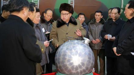 Nordkoreas Machthaber Kim Jong Un mit einem angeblichen Atomsprengkopf, aus dem einige Kabel ragen.