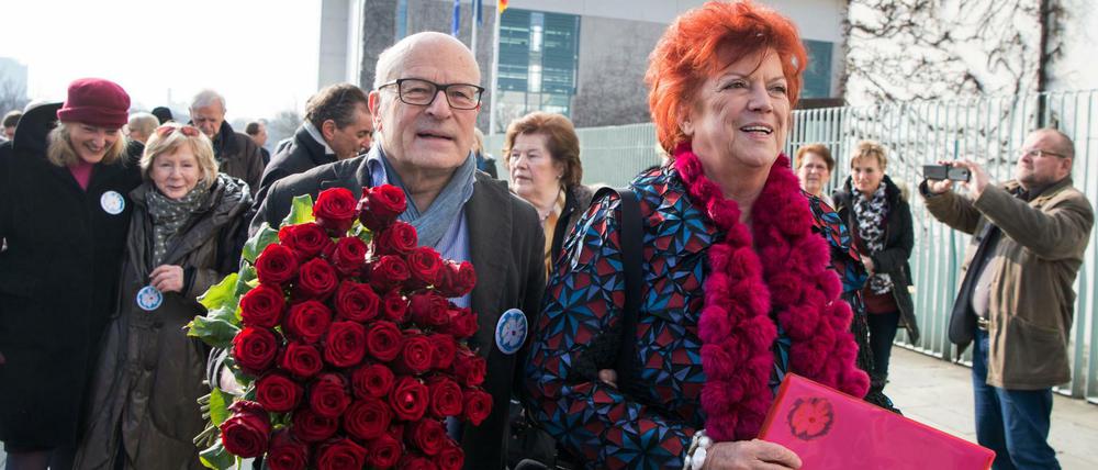 Regina Ziegler (r) und Volker Schlöndorff übergeben am Weltfrauentag am Bundeskanzleramt in Berlin einen Brief und einen Blumenstrauß für Bundeskanzlerin Merkel, als Dank für ihre Flüchtlingspolitik. 