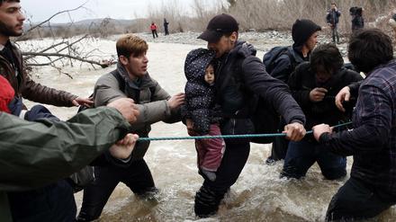 Füchtlinge brachen am Montag aus dem griechischen Lager Idomeni auf und suchten einen Weg nach Mazedonien. Dabei mussten sie auch einen Fluss überqueren.