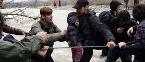 Füchtlinge brachen am Montag aus dem griechischen Lager Idomeni auf und suchten einen Weg nach Mazedonien. Dabei mussten sie auch einen Fluss überqueren.