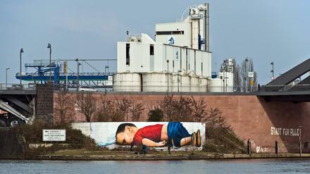 Im September 2015 wurde an der türkischen Kueste ein kleiner syrischer Junge angespüllt - ertrunken auf der Flucht. Jetzt prangt es als Graffito auf einer Mauer am Frankfurter Osthafen, unweit der Europaeischen Zentralbank.