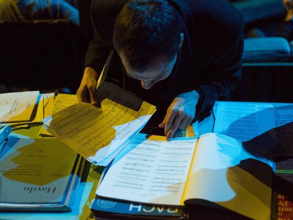 Stöbern nach Noten. Die Zuschauer können dem Pianisten bereitliegendes Material vorlegen - vielleicht spielt er's ja.