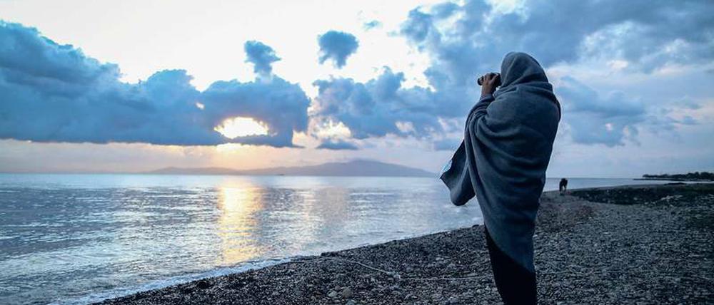 Es geht um Menschen, nicht um „Ströme“. Ein Helfer sucht am Strand von Lesbos das Meer nach Booten ab.