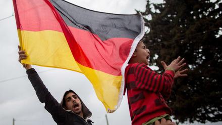 Neue Patrioten. Eine Deutschlandfahne schwenken Flüchtlinge im Lager in Idomeni an der Grenze zwischen Griechenland und Mazedonien und rufen "Mama Merkel".