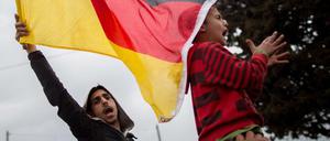 Neue Patrioten. Eine Deutschlandfahne schwenken Flüchtlinge im Lager in Idomeni an der Grenze zwischen Griechenland und Mazedonien und rufen "Mama Merkel". 