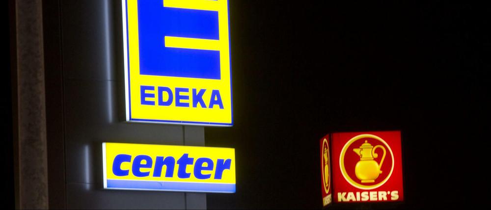 Die Leuchtreklamen von zwei Supermärkten der Ketten Kaiser's Tengelmann und Edeka, aufgenommen in Berlin.