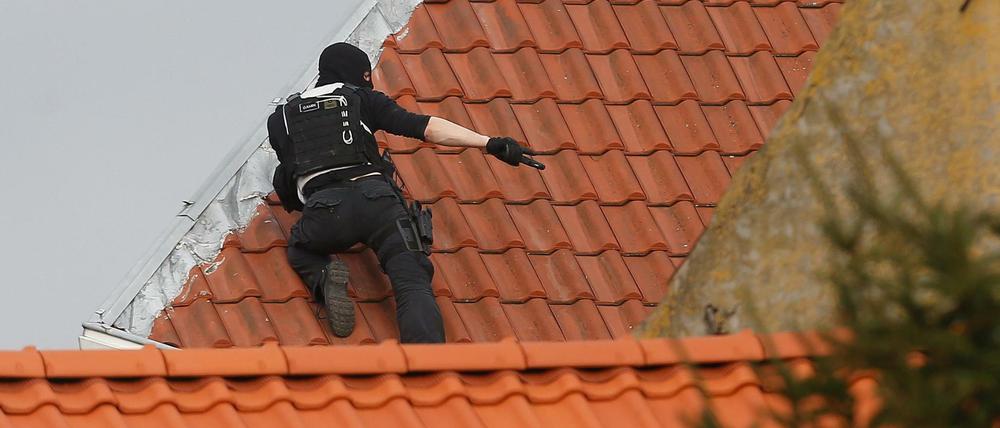 Ein Polizist auf einem Dach im Brüsseler Stadtteil Forest. Bei einem Anti-Terror-Einsatz hatte ein Unbekannter das Feuer auf die Beamten eröffnet.