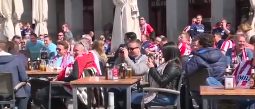 Fans des Fußballvereins PSV Eindhoven begrölen Bettler in Madrid, denen sie zuvor Geld hingeworfen hatten. 