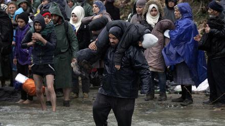 Flüchtlinge bei der Überquerung eines Flusses nahe des Flüchtlingslagers in Idomeni.