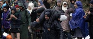 Flüchtlinge bei der Überquerung eines Flusses nahe des Flüchtlingslagers in Idomeni. 