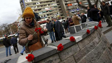 Eine Frau in Ankara legt Blumen als Gedenken auf eine Mauer. Am Sonntag waren bei einem Anschlag in Ankara 35 Menschen getötet worden