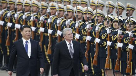 Bundespräsident Joachim Gauck and Chinas Präsident Xi Jinping schreiten vor der Großen Halle des Volkes in China die Ehrengarde ab.