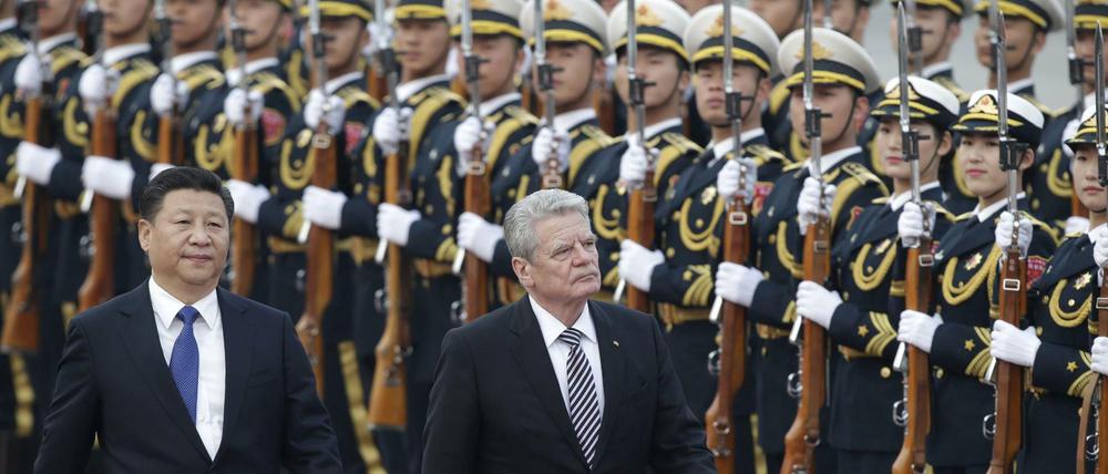 Bundespräsident Joachim Gauck and Chinas Präsident Xi Jinping schreiten vor der Großen Halle des Volkes in China die Ehrengarde ab.