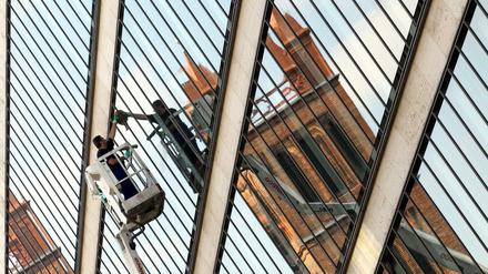 Sorgt für Durchblick. Ein Fensterputzer am Auswärtigen Amt, im Spiegel die Friedrichswerdersche Kirche. 