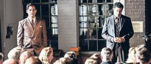 Rudi Dassler (Torben Liebrecht, links) und Adi Dassler (Ken Duken) verkünden der Belegschaft, dass der Betrieb in zwei Firmen getrennt wird. 