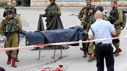 Israelische Soldaten tragen den getöteten Palästinenser weg.