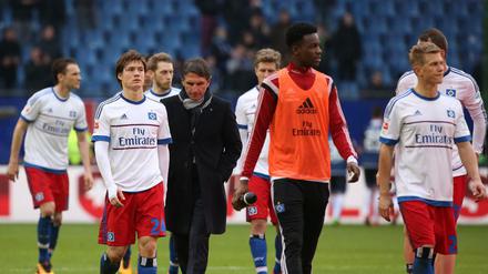 Hamburgs Trainer Bruno Labbadia (M) und seine Spieler gehen nach der bitteren 1:3-Niederlage gegen Hoffenheim zu den Fans. 