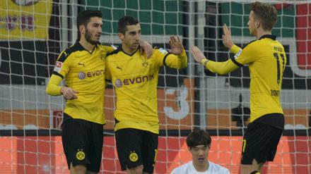 Die Dortmunder Nuri Sahin (l) und Marco Reus (re.) gratulieren Henrikh Mkhitaryan nach dessen Tor zum 1:1-Ausgleich.