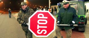 Ein deutscher und ein polnischer Polizist räumen am Grenzübergang Forst-Sacro gemeinsam ein Stoppschild zur Seite. Das war Ende 2007, zum Beitritt Polens zum Schengen-Raum.