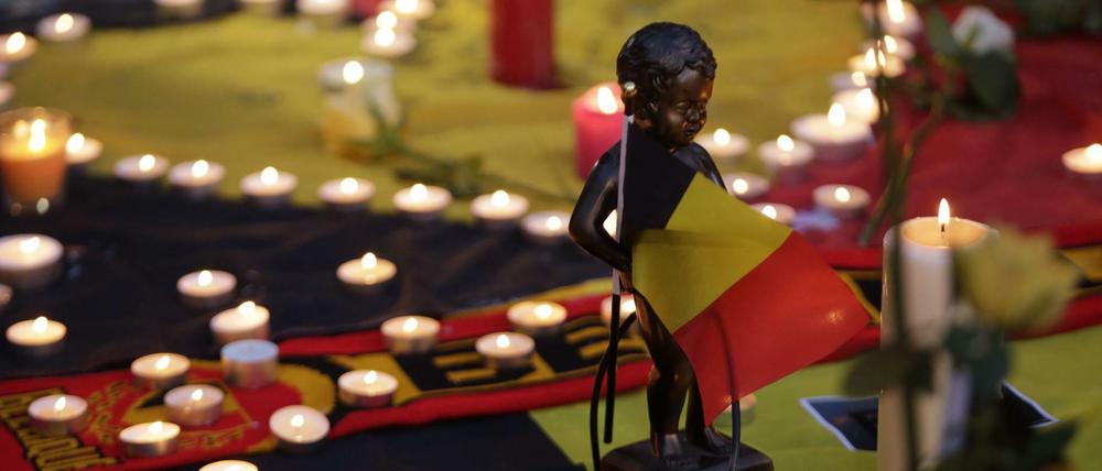 Eine Miniaturskulptur von Manneken Pis hält die belgische Flagge. Am Place de la Bourse (Beursplein) in Brüssel trauern die Menschen.
