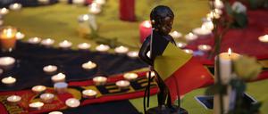 Eine Miniaturskulptur von Manneken Pis hält die belgische Flagge. Am Place de la Bourse (Beursplein) in Brüssel trauern  die Menschen.
