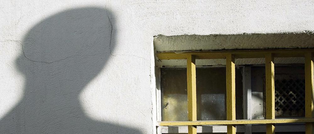 Der Schatten eines Mannes ist am 7. November 2009 neben dem letzten erhaltenen Gitterfenster des ehemaligen Geschlossenen Jugendwerkhofes Torgau in der heutigen Gedenkstätte in Torgau zu sehen.