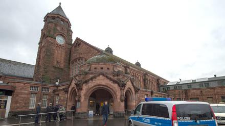 Ein Polizeifahrzeug und bewaffnete Polizisten stehen vor dem Hauptbahnhof in Gießen.