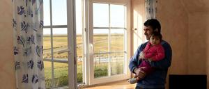Zukunft auf der Insel (hier ein syrischer Vater auf der Nordseehallig Langeneß)? Die großen Städte sehen ihre Attraktivität für hilfsbedürftige Neubürger mit Sorge.