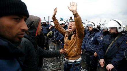 Konfrontation im Grenzgebiet: Ein Flüchtling zwischen anderen Flüchtlingen und griechischen Polizisten am Ostersonntag in Idomeni.