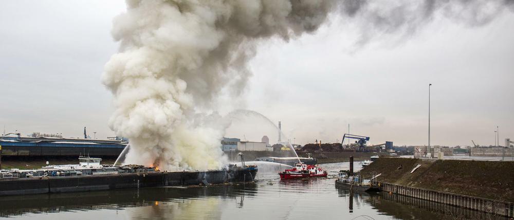Ein Feuerlöschboot löscht am Donnerstag in Duisburg ein Schiff. Zwei Menschen sind bei Arbeiten auf dem Tankschiff in einer Werft im Duisburger Hafen ums Leben gekommen.