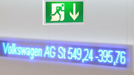 Ein Hinweisschild für einen Notausgang ist in der Börse in Frankfurt am Main vor einem elektronischen Laufband mit dem DAX-Wert von Volkswagen zu sehen.