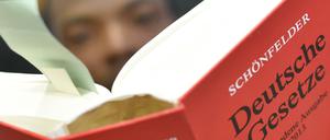 Ein Flüchtling aus Somalia hält eine Ausgabe "Schönfelder Deutsche Gesetze" in Händen.