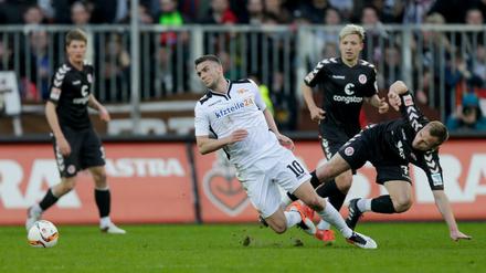  Berlins Dennis Daube (M) setzt sich gegen St. Paulis Bernd Nehrig (r) durch. 