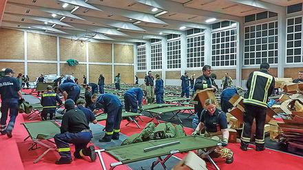 Wann werden die Notunterkünfte, wie hier die Onkel-Tom-Sporthalle, wieder geräumt? Noch streiten und verhandeln Bezirk, Senat und die Parteien um neue Standorte und Flächen für dauerhafte Container für die Flüchtlinge. Dieses Foto stammt aus dem Herbst 2015 und zeigt den Aufbau der Unterkunft für die Menschen, die dort seit November wohnen.
