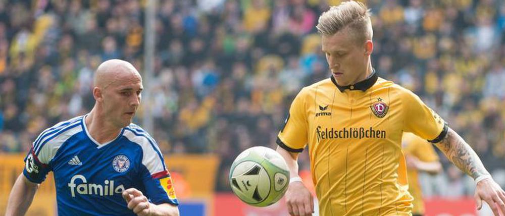 Reicht noch nicht. Dynamo Dresden und Marvin Stefaniak (r. im Duell mit Kiel Patrick Herrmann) müssen die Aufstiegsfeier noch aufschieben.