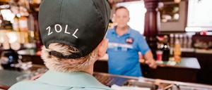 Eine Zollbeamtin nimmt die Daten eines Mitarbeiters auf, um anschließend überprüfen zu können, ob hier der gesetzlich vorgeschriebene Mindestlohn durch den Arbeitgeber gezahlt wird. 