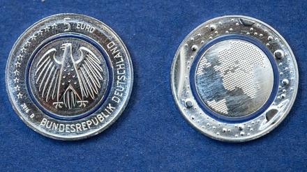 Die neue deutsche Fünf-Euro-Münze "Blauer Planet Erde". Die sogenannte "Tri-Material-Coin" hat in der Mitte einen durchsichtigen, blau schimmernden Ring aus Kunststoff, der Euromünzen in Zukunft besser vor Fälschungen schützen soll.