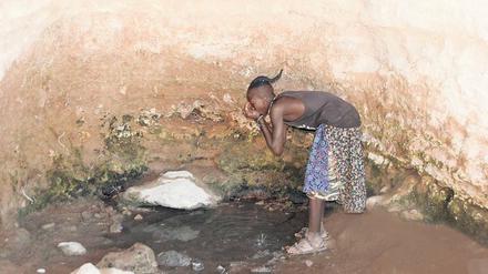 Wasser in der Wüste: Ein Himba-Junge stillt seinen Durst in einer der wenigen noch wasserspendenden Schichtquellen im Norden der Kalahari.