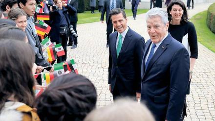 In guter Stimmung. Bundespräsident Joachim Gauck (r) und der mexikanische Präsident Enrique Pena Nieto werden am 11. April in Berlin im Schloss Bellevue nach den militärischen Ehren von einer Schülergruppe begrüßt. Heute trifft Nieto die Bundeskanzlerin. Beide Länder eint ein gemeinsames Verständnis ihrer Rolle in der internationalen Politik – als Partner bei der Lösung globaler Probleme wie dem Klimawandel und der Abrüstung. 