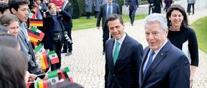In guter Stimmung. Bundespräsident Joachim Gauck (r) und der mexikanische Präsident Enrique Pena Nieto werden am 11. April in Berlin im Schloss Bellevue nach den militärischen Ehren von einer Schülergruppe begrüßt. Heute trifft Nieto die Bundeskanzlerin. Beide Länder eint ein gemeinsames Verständnis ihrer Rolle in der internationalen Politik – als Partner bei der Lösung globaler Probleme wie dem Klimawandel und der Abrüstung. 