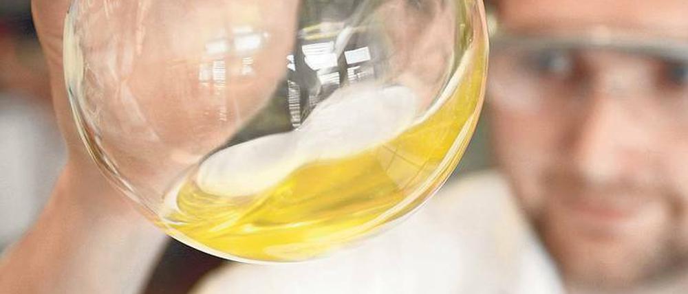 Hoffnung in goldgelb: Mathias Dimde, wissenschaftlicher Mitarbeiter im Team von Dirk Steinhilber und Professor Rainer Haag, schwenkt einen Glaskolben mit dendritischem Polyglycerin.