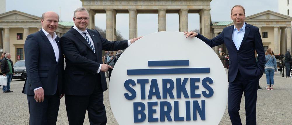 Wahlkampfleiter Kai Wegner (CDU, l-r), Kampagnenmanager Thomas Heilmann (CDU) und der CDU-Landesvorsitzende Frank Henkel posieren vor dem Brandenburger Tor. 