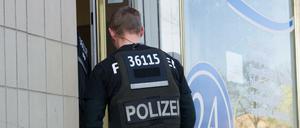Ein Polizist betritt am 21.04.2016 ein Büro einer Pflegefirma in Berlin. Mit einem Großaufgebot von Beamten ist die Berliner Polizei gegen organisierten Betrug bei Pflegeabrechnungen vorgegangen. Foto: Paul Zinken/dpa (zu dpa "Razzia gegen betrügerischen Pflegedienst in Berlin" vom 21.04.2016) +++(c) dpa - Bildfunk+++