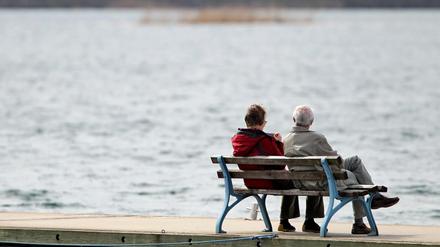Ein Rentnerpaar genießt die Sonne auf einer Bank im Hafen am Cospudener See in Leipzig. 