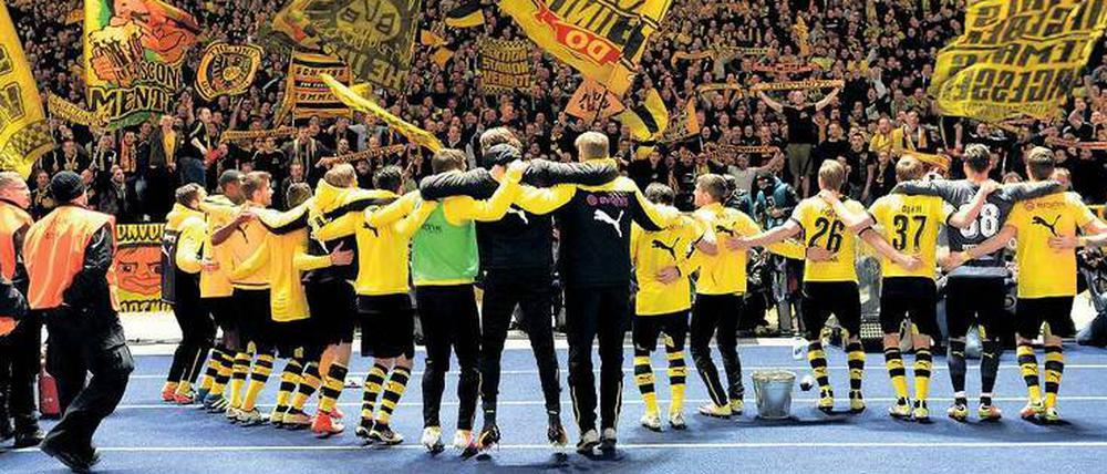 Können sich wieder in den Armen liegen. Die Dortmunder Profis lassen sich von ihren Fans für ihre Vorstellung im Olympiastadion feiern. Foto: dpa/Kastl