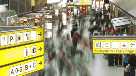 Passagiere laufen durch den Flughafen Tegel. 